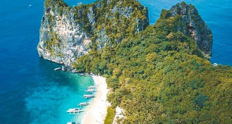 Vue aérienne d'une île tropicale entourée de bateaux.