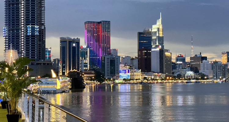 Skyline nocturno de la Ciudad de Ho Chi Minh reflejándose en el Río Saigón con luces de colores