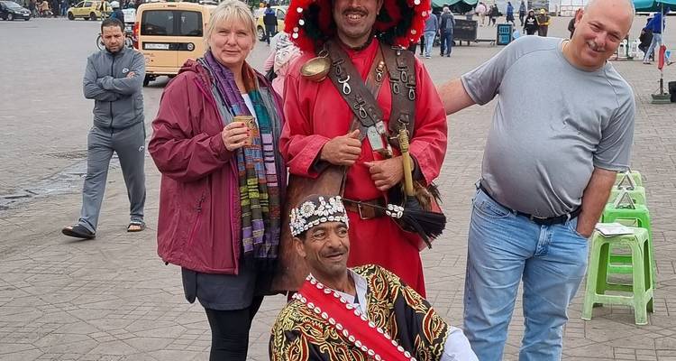 Groupe d'adultes vêtus de tenues traditionnelles posant avec des touristes.
