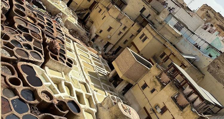 Vue aérienne d'une tannerie traditionnelle en cuir avec des cuves de teinture colorées.