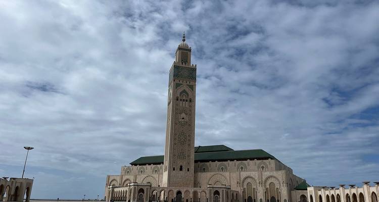Grande mosquée avec un minaret élevé contre un ciel nuageux.