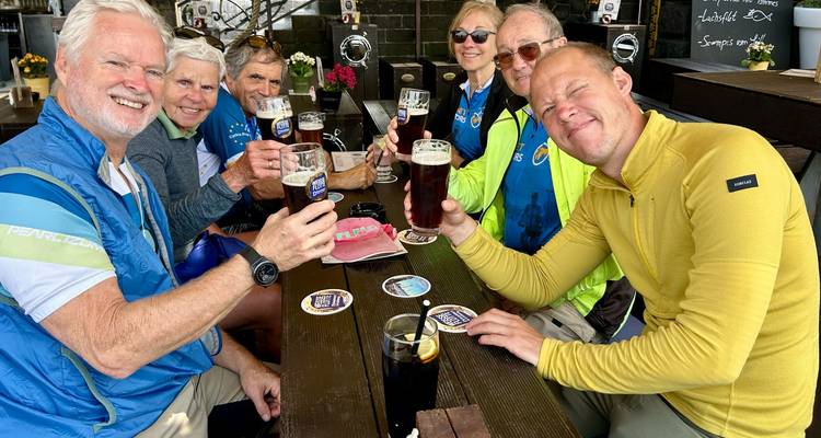Group of tourists enjoying drinks at an outdoor table.