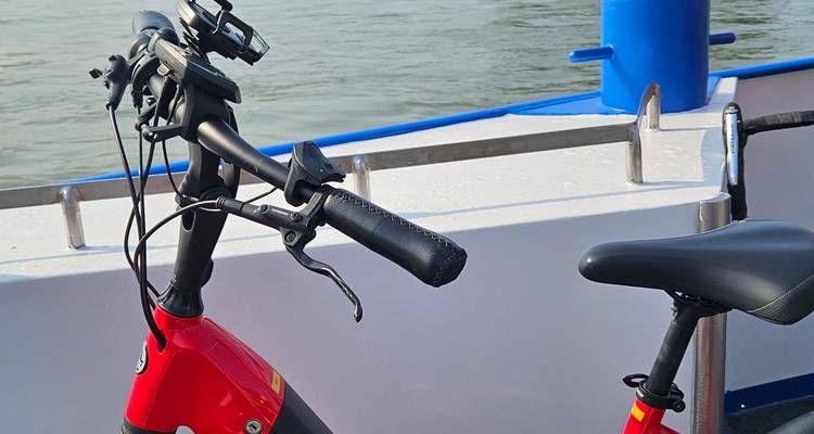 Bicycle handlebar on a boat near a body of water.