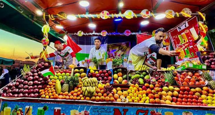 Étal de fruits coloré dans un marché marocain avec des vendeurs.