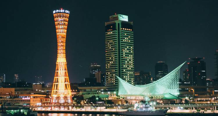 Tour du port de Kobe illuminée la nuit avec paysage urbain.