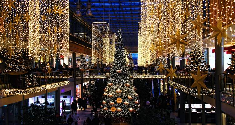 Christmas market inside a mall with Christmas trees and lights.