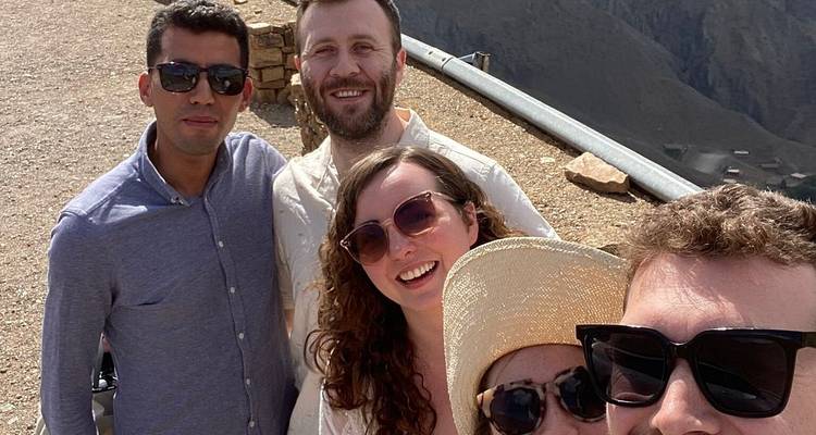 A group of friends taking a selfie with mountains in the background.