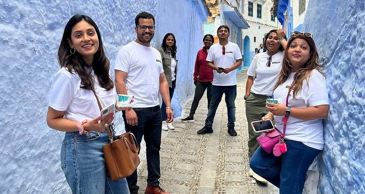 Un groupe de touristes dans une ruelle étroite bleue.
