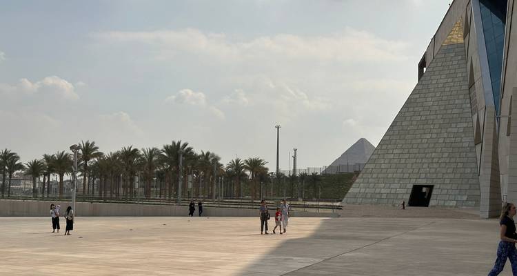 Piramide en palmbomen in een stedelijke omgeving.