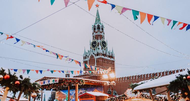Scène festive avec des drapeaux et une grande tour d'horloge en arrière-plan.