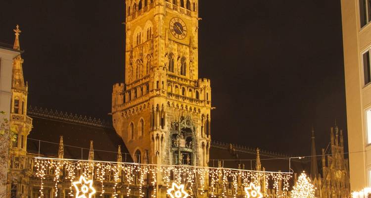 Hôtel de ville de style gothique illuminé la nuit avec un éclairage festif.