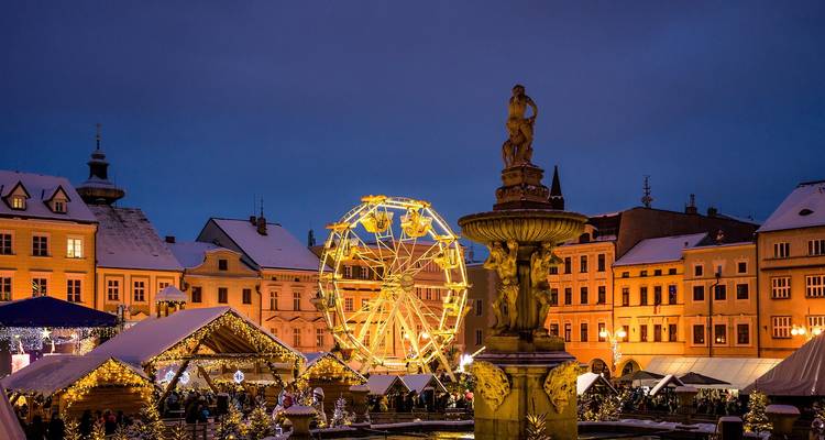 Marché de Noël animé au crépuscule avec une grande roue.