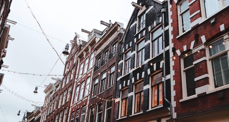 Vue architecturale de bâtiments européens traditionnels avec éclairages décoratifs.