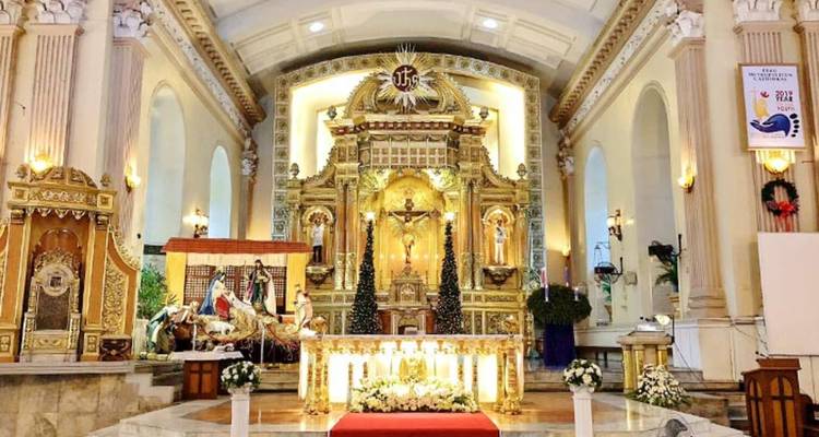 Intérieur d'une église ornée avec retable doré et décorations.