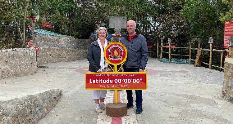 Ein Paar steht am Äquator, markiert durch ein Schild.
