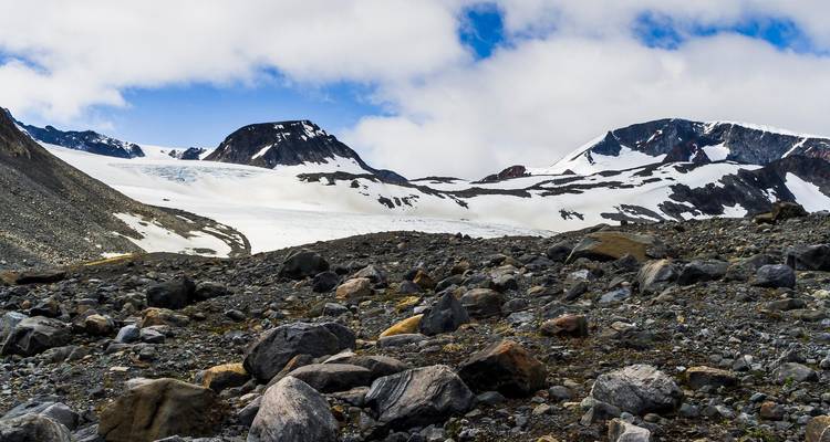 Mountain landscape with rocky terrain and snow patches.