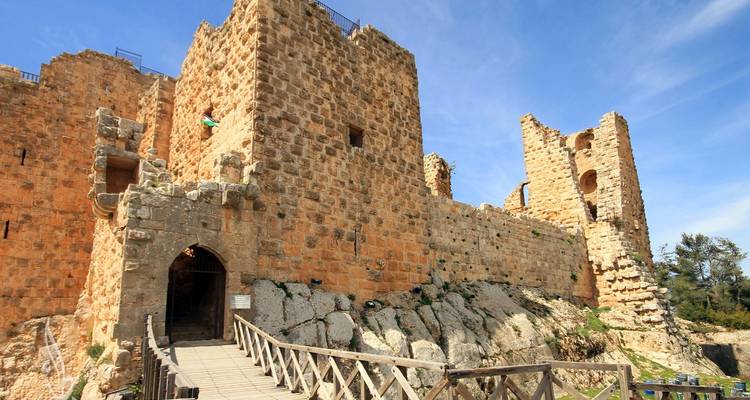 Ruina de fortaleza de piedra con puente de madera.