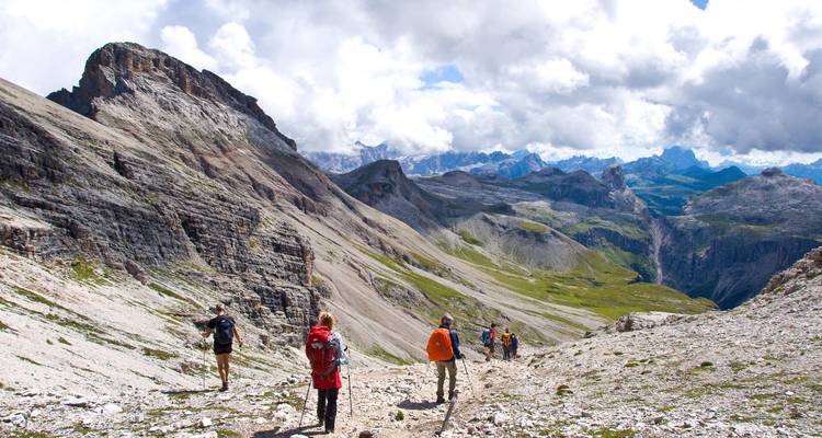 Group of hikers walking in a dramatic mountain landscape.