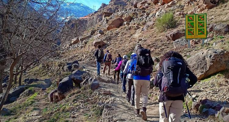 Groep wandelaars die lopen op een rotsachtig bergpad.
