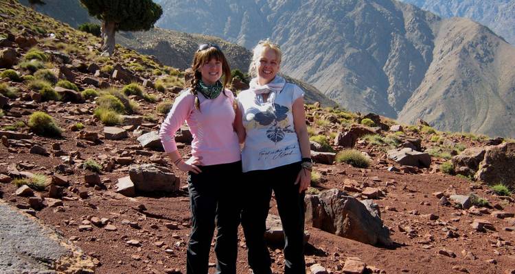 Twee vrouwen die poseren op een rotsachtig berglandschap.