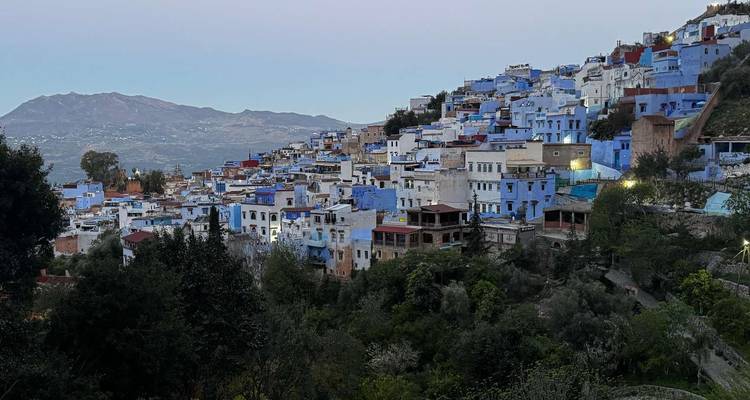 View of Chefchaouen with blue-painted buildings and mountains.