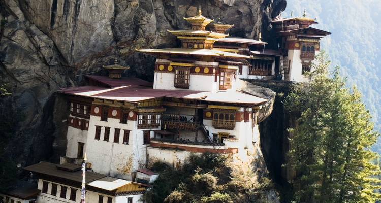 Une vue rapprochée et nette du monastère de Tiger's Nest accroché aux falaises de granite rugueuses parmi les pins.