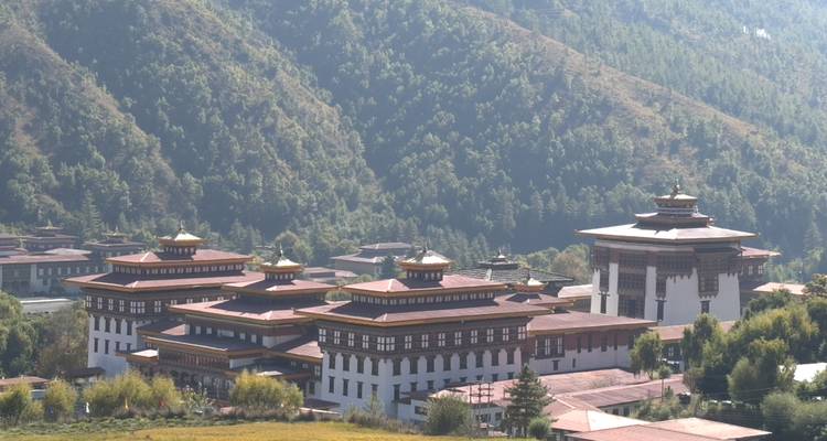 Un vaste complexe de dzong bhoutanais occupe le fond d'une vallée fertile encadrée par des collines boisées.