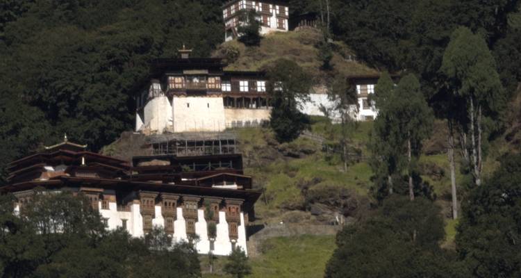 Des monastères blancs groupés sur les collines s'élèvent au-dessus de pentes verdoyantes et d'arbres hauts.