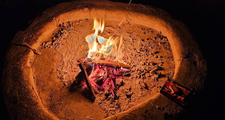 Feu de camp brûlant dans un aménagement circulaire de pierres la nuit.