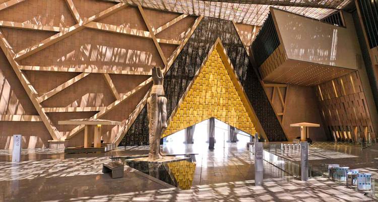 Hall intérieur du Grand Musée égyptien avec portail en forme de pyramide jaune et ombres à motifs