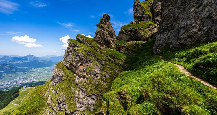 Falaises rocheuses avec vue sur une vallée et une ville.