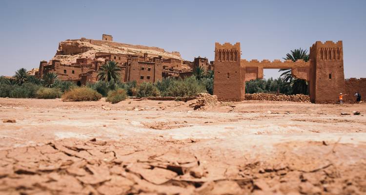 Ruines architecturales anciennes entourées d'un paysage verdoyant.
