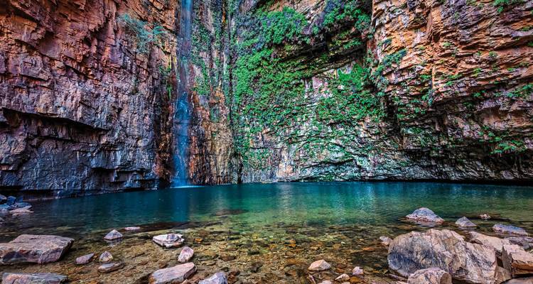 Waterfall cascading into a turquoise pool within rocky walls.