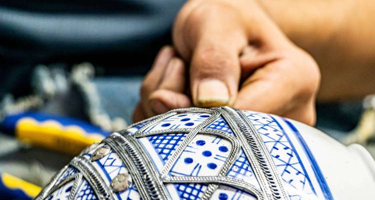 An artisan working on a traditional pottery piece.