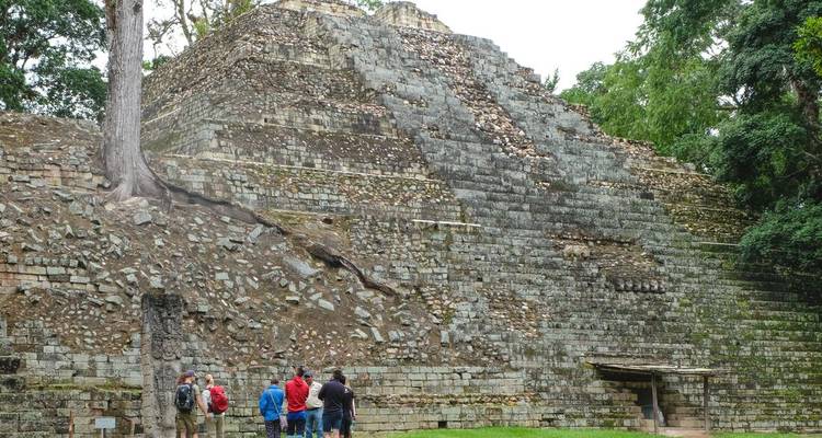 Groupe de touristes explorant d'anciennes ruines mayas.