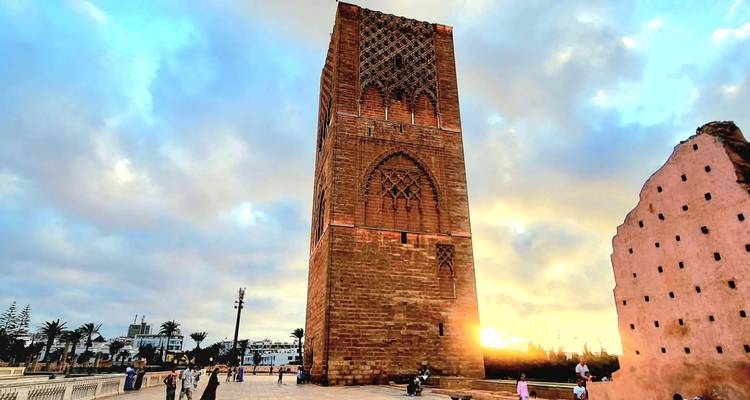 Hoge historische toren met ingewikkelde patronen bij zonsondergang.