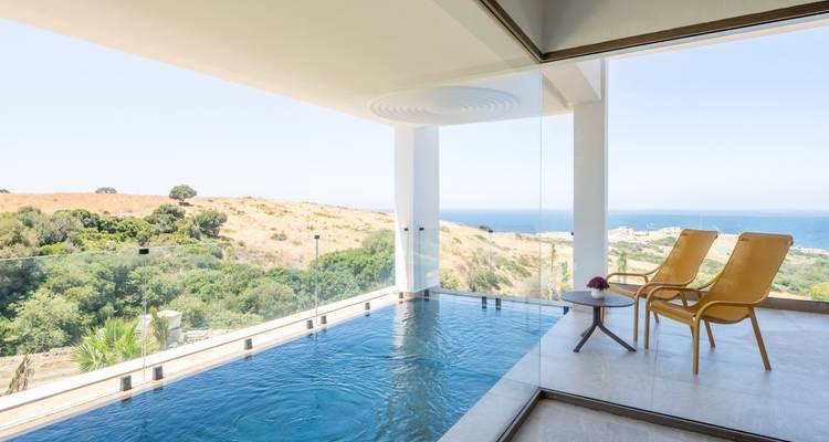 Binnenbad met uitzicht op de oceaan door grote ramen.