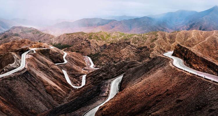 Winding mountain road with scenic views of mountains.