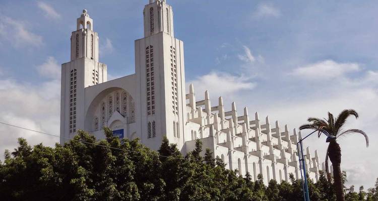 White cathedral-like structure with towers and trees.