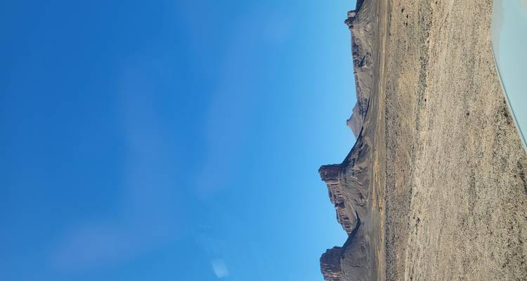 Woestijnscène met rotsformaties onder een heldere hemel.