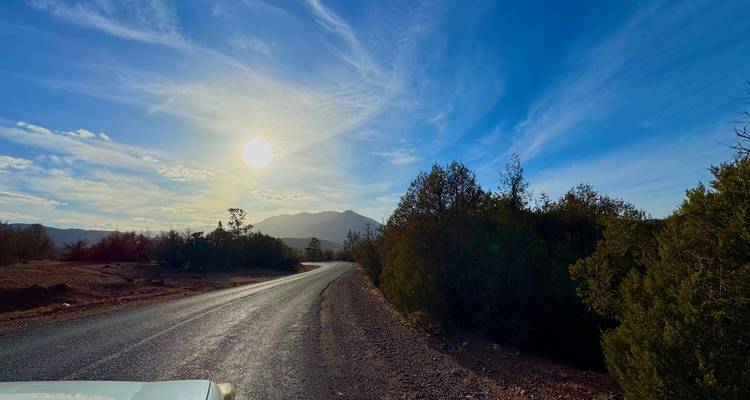 Une route désertique pittoresque avec le soleil se couchant en arrière-plan.