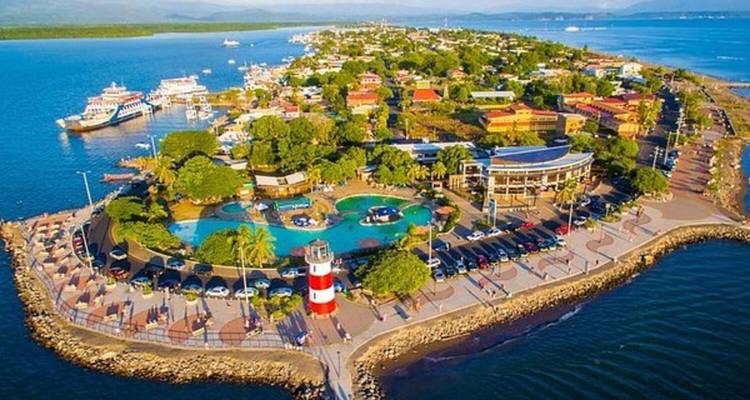 Vue aérienne d'une ville côtière avec un phare et une promenade.