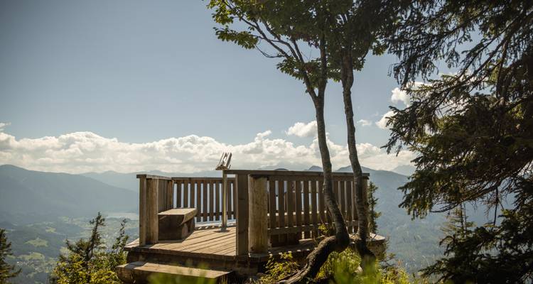 Point de vue en bois surplombant une vallée avec un ciel dégagé.