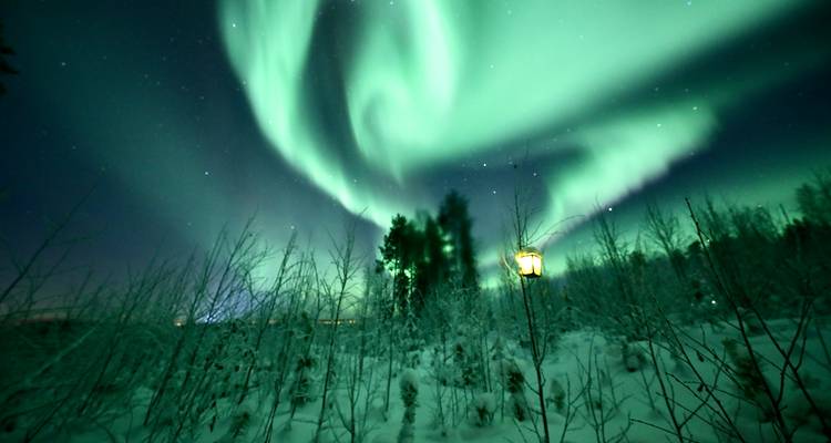 Aurore boréale sur un paysage enneigé.
