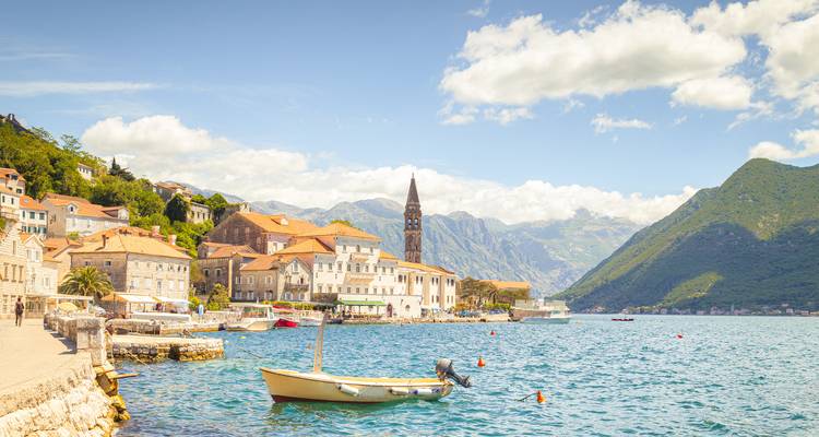 Un village pittoresque au bord de l'eau avec des montagnes.