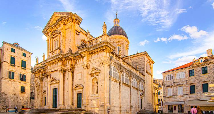 Cathédrale historique sur une place ensoleillée.