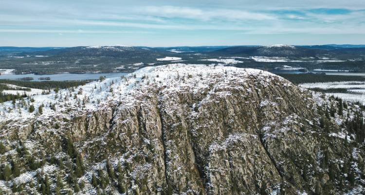 Snow-covered mountains with a forested landscape.