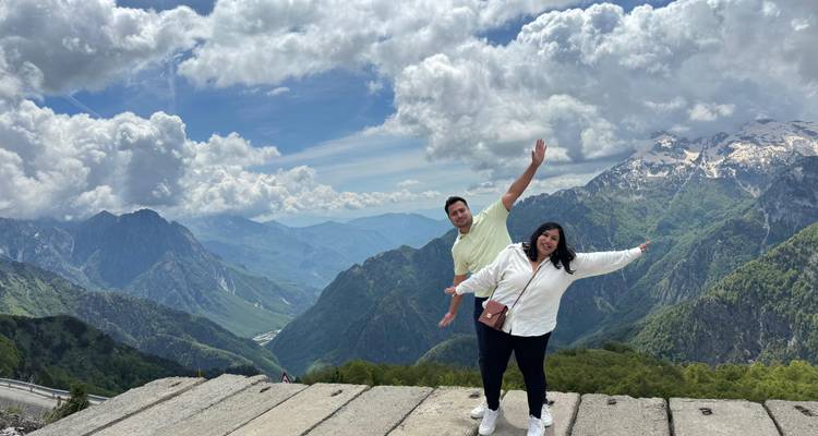 Zwei Personen posieren mit Berglandschaft im Hintergrund.