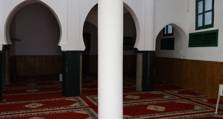 Inneres einer Moschee mit traditionellen Torbögen.
