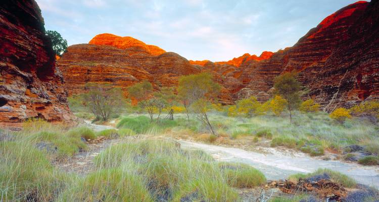 Scenic landscape with unique red rock formations and green vegetation.